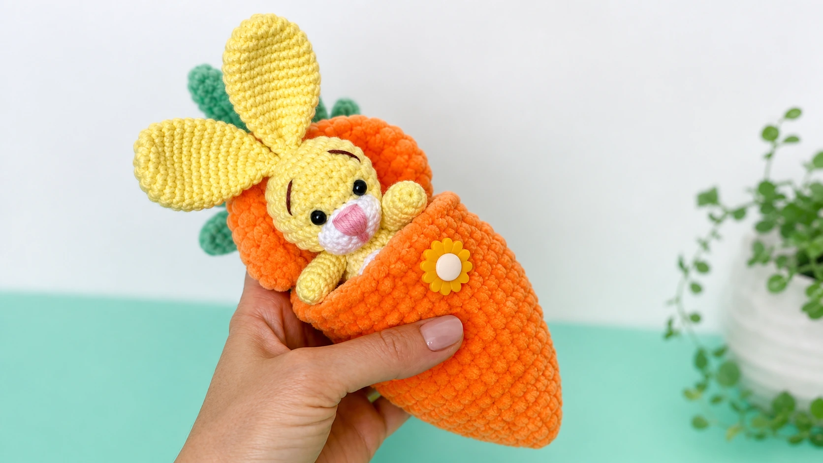 Free crochet pattern bunny shown as a small yellow amigurumi bunny tucked inside an orange crochet carrot pouch.